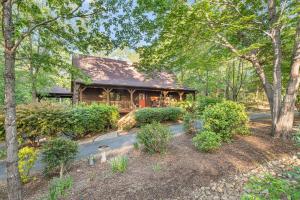 una baita di tronchi con portico nel bosco di Lake Lure Oasis in the Woods w/ Hot Tub & More! a Lake Lure