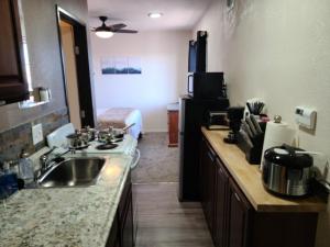 a kitchen with a sink and a room with a bed at 069A Private Studio with kitchen near South Rim Sleeps 4 in Valle
