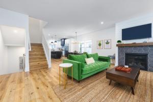 a living room with a green couch and a fireplace at Bonjour Soha- pool- close to beach in South Haven