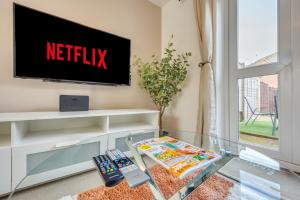 a living room with a tv on a wall at Oakbridge House - 6 mins drive to CMK - Free Parking, Fast WiFi, Smart TVs with Sky and Netflix by Yoko Property in Milton Keynes