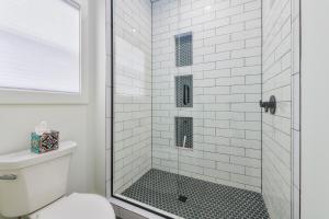 a white bathroom with a shower with a glass door at Bonjour Soha- pool- close to beach in South Haven +44 photos