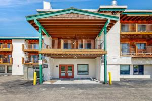 a apartment building with a balcony and a red door at Three Seasons Condominiums in Crested Butte