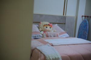 a teddy bear sitting on top of a bed at Erki Guest House in Abu Simbel