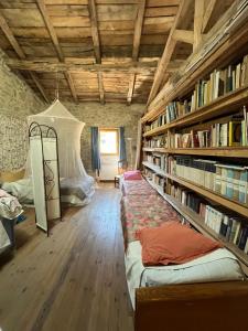 Zimmer mit einem Bett und einem Bücherregal mit Büchern in der Unterkunft Le Refuge Familial in Fondamente