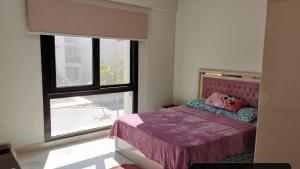 a bedroom with a bed and a large window at Chalet Verdi Marassi view lagoon in El Alamein
