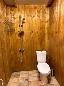 a bathroom with a toilet in a wooden wall at Blue Oasis Lozenets in Kiten