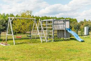 un parco giochi con due altalene e uno scivolo di Domek Życiny nad Zalewem Chańcza a Życiny