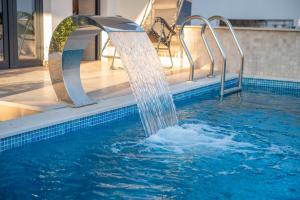 a pool with a water fall in a swimming pool at Premium Berlin with Pool in Ulcinj