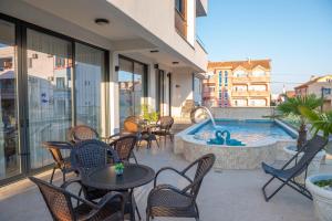 een patio met tafels en stoelen en een zwembad bij Premium Berlin with Pool in Ulcinj