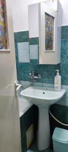 a bathroom with a sink and a mirror at Holidays Apartment in Constanţa