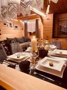 mesa de comedor con velas y copas de vino en SZAŁAS CHALET PRZY POTOKU Gospodarstwo Agroturystyczne Baciary, en Krauszów