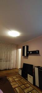 a living room with a couch and a tv on the wall at Holidays Apartment in Constanţa