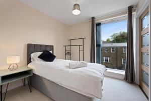 een slaapkamer met een bed en een groot raam bij High Wycombe Short Stay Apartment in High Wycombe