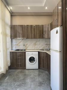 a kitchen with a washer and a white refrigerator at Buzovna Delmar Luxury Residence in Baku