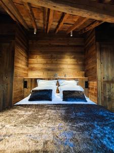 a bedroom with a large bed with wooden walls at Les Fermes de Cal Panche : Le Cabanat in Les Angles