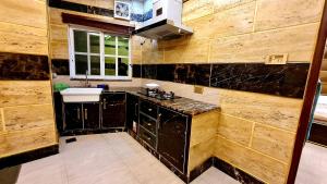 a kitchen with wooden walls and a sink and a counter at B&B Apartment & Hotels in Lahore