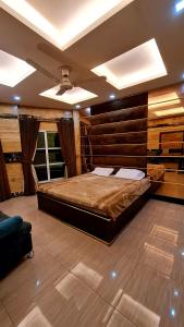 a bedroom with a large bed with a wooden wall at B&B Apartment & Hotels in Lahore