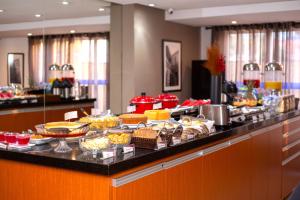 un buffet avec de nombreux types de nourriture différents dans l'établissement Nobile Hotel Juiz de Fora, à Juiz de Fora