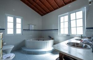 Un baño con bañera, lavabo e inodoro. en Azores Palmeira Villa, en Ponta Delgada 41 fotos más