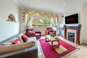 a living room with a couch and a fireplace at Barnet Serviced Accommodation - Elegant 5-Bedroom Home, Just a 7-Minute Stroll from High Barnet Station - Book Your Stay Today!" in New Barnet