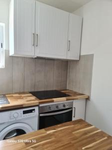 a kitchen with white cabinets and a dishwasher at AP Luso Brasileiro in Lajes das Flores