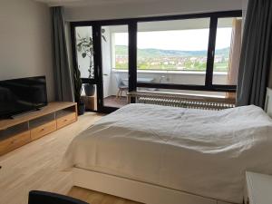 a bedroom with a bed and a flat screen tv at Freshly renovated Studio apartment - top location in Weinstadt in Weinstadt