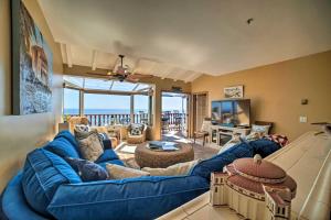 a living room with a blue couch and a television at Lux Oceanfront Villa With Breathtaking Views in Avalon