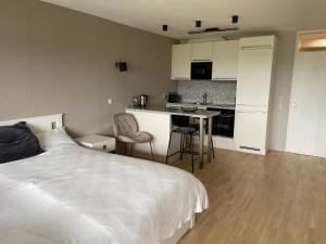 a bedroom with a white bed and a kitchen at Freshly renovated Studio apartment - top location in Weinstadt in Weinstadt