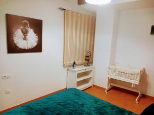 a bedroom with a green bed and a crib at Apartamento Valentino's- Alpujarra in Carataunas