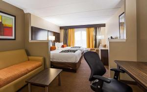 Habitación de hotel con cama y sofá en Sonesta Essential Orlando en Orlando