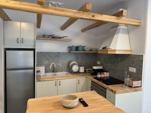 a kitchen with a refrigerator and a wooden table at My Inner Mykonos Apartment in Ano Mera