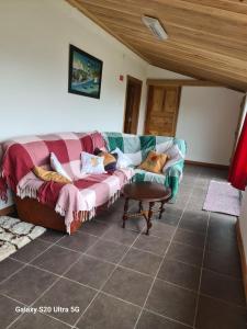 a living room with a couch and a table at AP Luso Brasileiro in Lajes das Flores