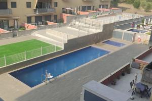 eine Aussicht auf den Pool eines Gebäudes in der Unterkunft Apartamento nuevo con piscina y amplio balcon in Sant Carles de la Ràpita