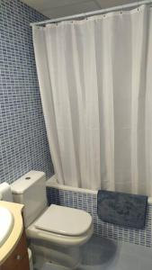 ein Bad mit einem WC und einem Duschvorhang in der Unterkunft Apartamento nuevo con piscina y amplio balcon in Sant Carles de la Ràpita
