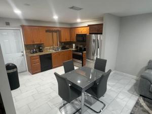 a kitchen with a table and chairs and a refrigerator at The place to Be in Miami Gardens