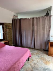 um quarto com uma cama rosa e cortinas cinzentas em Casa Anna a Pietrasanta in Toscana em Pietrasanta
