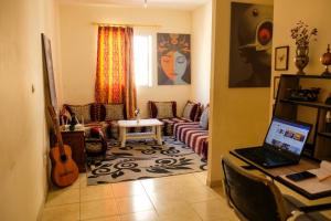 a living room with a couch and a table with a laptop at Room in Agadir with shared bathroom in Agadir