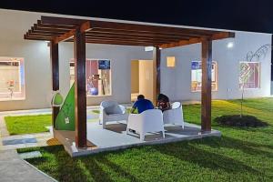 a person sitting at a table in a gazebo at Casa Aconchegante B in Guanamby