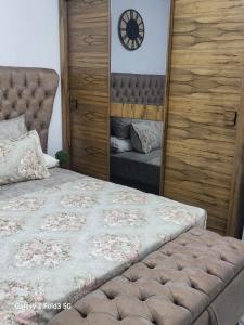 شالية غرفة ورسيبشن وحمام ومطبخ أرضي بجاردن خاص في بورسعيد: غرفة نوم بسرير وساعة على الحائط