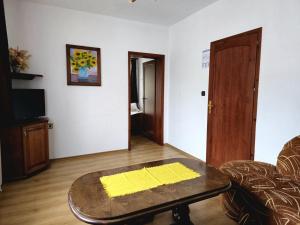 een woonkamer met een salontafel en een televisie bij Къща за гости Чаршията in Smolyan