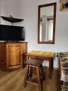 een woonkamer met een tafel en een spiegel bij Къща за гости Чаршията in Smolyan