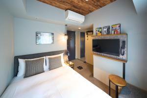 a bedroom with a large bed with a tv on the wall at Hotel Resol Akihabara in Tokyo +155 photos