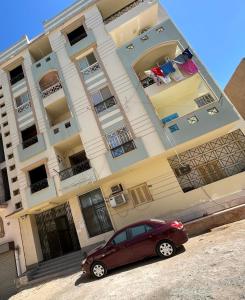 a red car parked in front of a building at Apartment Hossam 1 in Hurghada