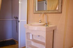 a bathroom with a sink and a mirror at Camel Trips Luxury Camp in Merzouga