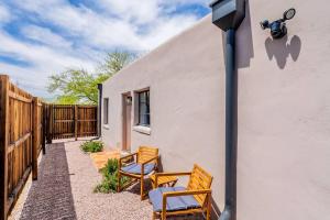 a patio with two chairs and a table with a camera at Cute & Cozy 2BR 1BA Adobe w Firepit Near UA & UMC, Low Summer Rates! in Tucson