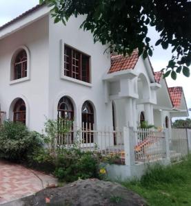 ein weißes Haus mit einem Zaun davor in der Unterkunft Beautiful House Colombia in Burrero