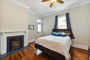 a bedroom with a bed and a fireplace at Stunning Uptown 3 Bedroom 3 Bathroom home in New Orleans