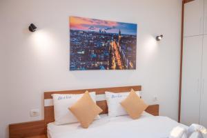 een slaapkamer met een bed en een schilderij aan de muur bij Premium Berlin with Pool in Ulcinj