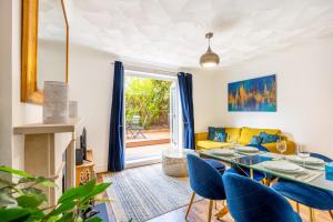 uma sala de estar com uma mesa e cadeiras azuis em Renovated 2-Storey 2BR wGarden near Angel St em Londres