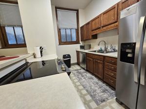 eine Küche mit Holzschränken und einem Kühlschrank aus Edelstahl in der Unterkunft City Hall Clerk's Office in Rochester